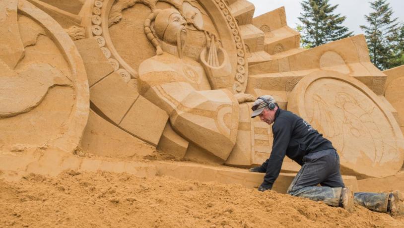 Skulptør arbejder på sandskulptur