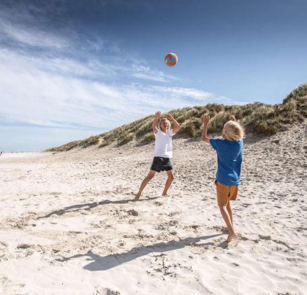 Børn spiller bold ved stranden