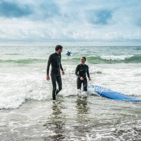 To mennesker der surfer i Vesterhavet 
